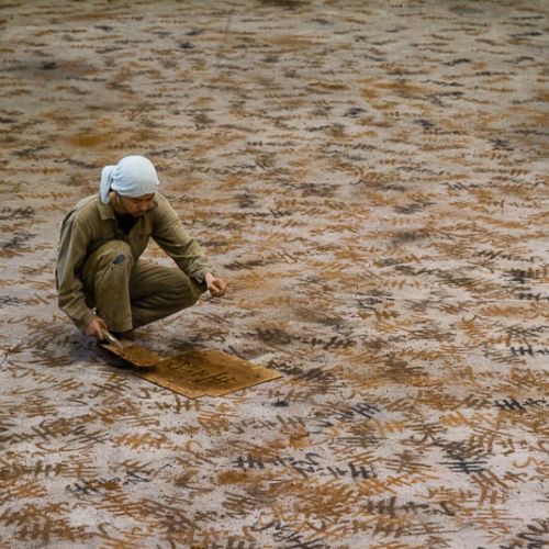 artist painting with sand the floor